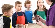 Kids listen as they hear how chocolate is made at The Chocolate Manor