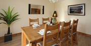 Ballintoy Harbour Dining Room with a table set for six people and an indoor plant.