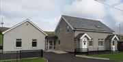 View of Dunluce Guide House from the front, further images of kitchen, TV room, twin room and dorm.
