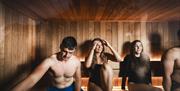 4 people relax in the sauna
