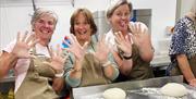 women cooking sourdough with flour all over their hands