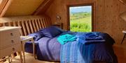 A view of the mezzanine bedroom loft - over the main area and tucked up into the roof.  with views out over the coast towards Castlerock and Downhill.