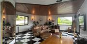 The dining table in The Loft at The Brass Goat, with the living space and windows onto the glen beyond