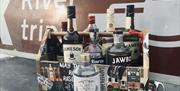 a crate filled with various whiskey and gin bottles sit on a table