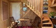 An internal view of the studio - view towards the stair to the mezzanine and the dining space with light flooding in.  A delightful and colourful cute