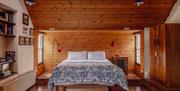 Bedroom in Kiln Wing with wooden panelling, china pattern bedspread, king size double bed