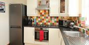 Titanic Kitchen fully fitted with a fridge, hob/oven, microwave, sink, coffee maker and a kettle.