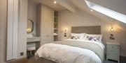 The Fisherman’s Reel bedroom with built in furniture, sloping ceiling and dormer window providing natural light, with double bed centred between 2 bed