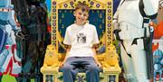 a young boy sits on a lego throne