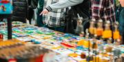 people examining various tables and rows of lego sculptures