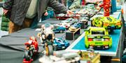 people examining various tables and rows of lego sculptures