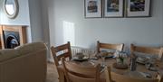 Dining table with 3 photos of Causeway Coast behind it