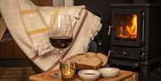 Cosy fireside scene with Peatlands sourdough bread, oil and vinegar dipping bowls, and glass of red wine