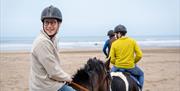 Group on horseback enjoying the Saddle Up by the Sea experience with Crindle Stables