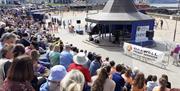 Crowds being entertained by performers at the bandstand