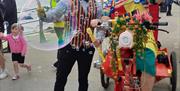 colourful performers surrounded by bubbles on the promenade in Portstewart