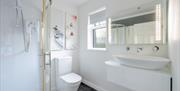 En-suite bathroom in Rowan Room featuring a corner glass shower enclosure, illuminated mirror, modern vessel basin vanity, and Asian-inspired artwork.