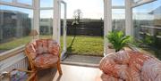Giant's Causeway Sunroom with Chairs and an open door leading to the back garden.