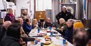 a tour group sit around a large table at Lacada Brewery