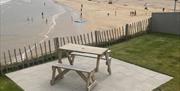 lower patio with picnic table looking over the beach