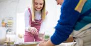 Zara guides a student using the potter's wheel