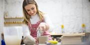 Zara works on a ceramic creation in her studio