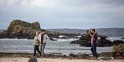 Group take a walk along the beach as part of the Giant Tours experience