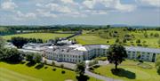 Drone view of the exterior at Roe Park Resort, fluorescent green natural surroundings and golf course.