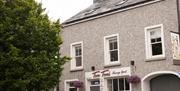 Causeway Squarings frontage showing entrance door beside Tom Tom's Bakery