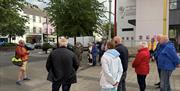 A tour group meeting with Sam at the Drumceatt square.