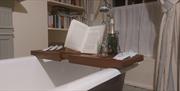 bath tray sits atop the bath holding a bottle of prosecco and an open book at Dromore House