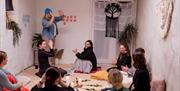 group of women in a room talking and joing their palms together