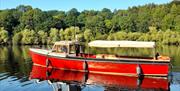 MV Kingfisher boat on the river with Mountsande in  background.