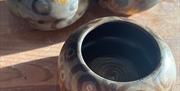 ceramic pots with different designs sitting on a wooden table