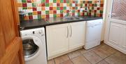 Utility room with washing machine and tumble dryer.