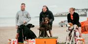 3 race contestants with their dogs on the winner's podium