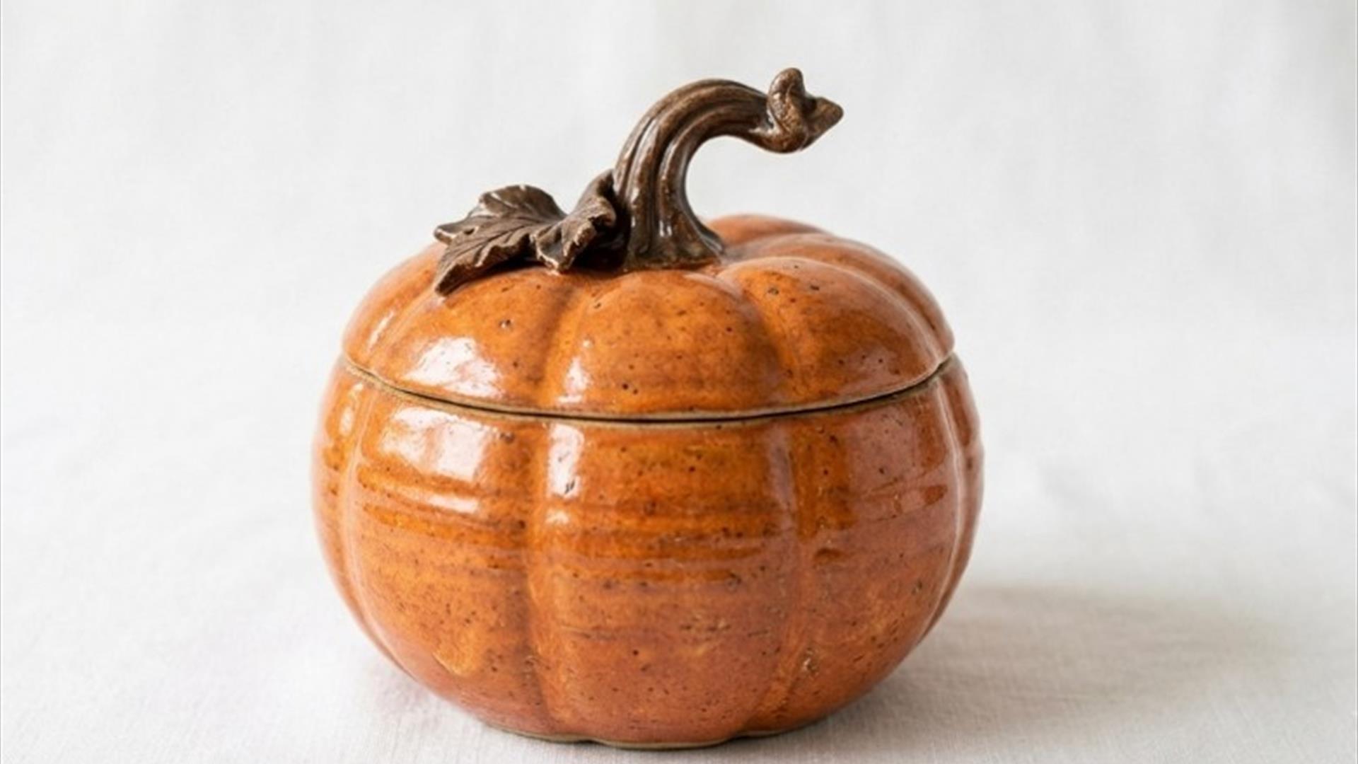 image of a ceramic pupmkin shaped bowl with lid on a white background. image of a ceramic pupmkin shaped bowl with lid on a white background.