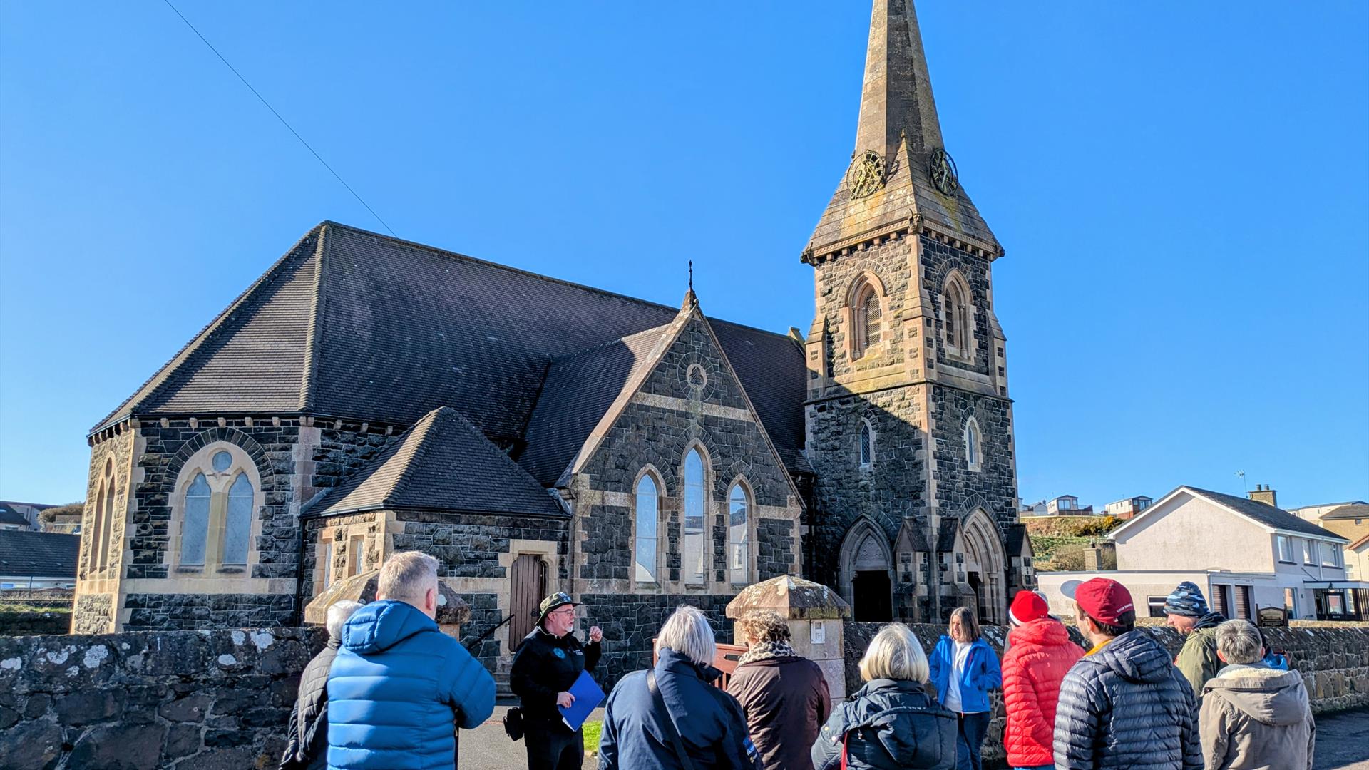 Bob Picken guiding a group dressed in outdoor clothing learning about the village of Castlerockclothing and hearing stories of the Earl Bishop Bob Picken guiding a group dressed in outdoor clothing learning about the village of Castlerockclothing and hearing stories of the Earl Bishop