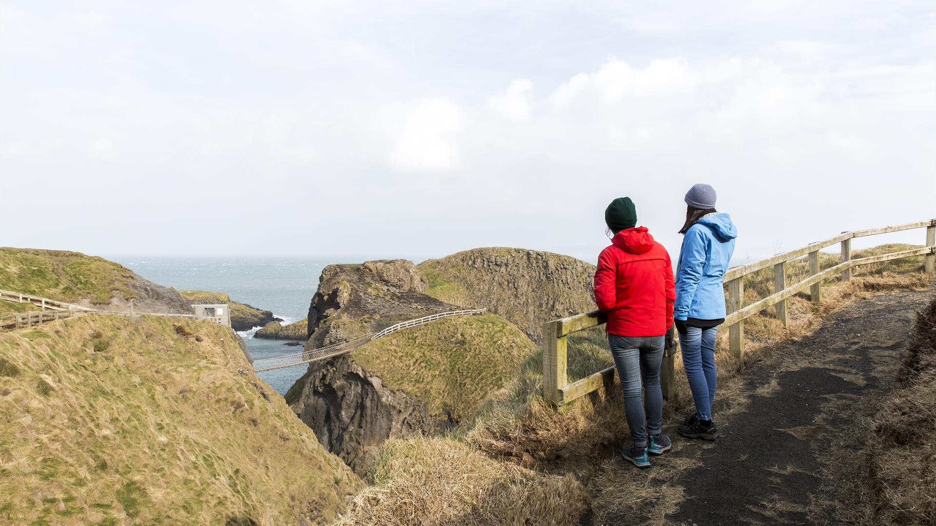 Two visitors admiring the views of Carrick-a-Rede Rope Bridge