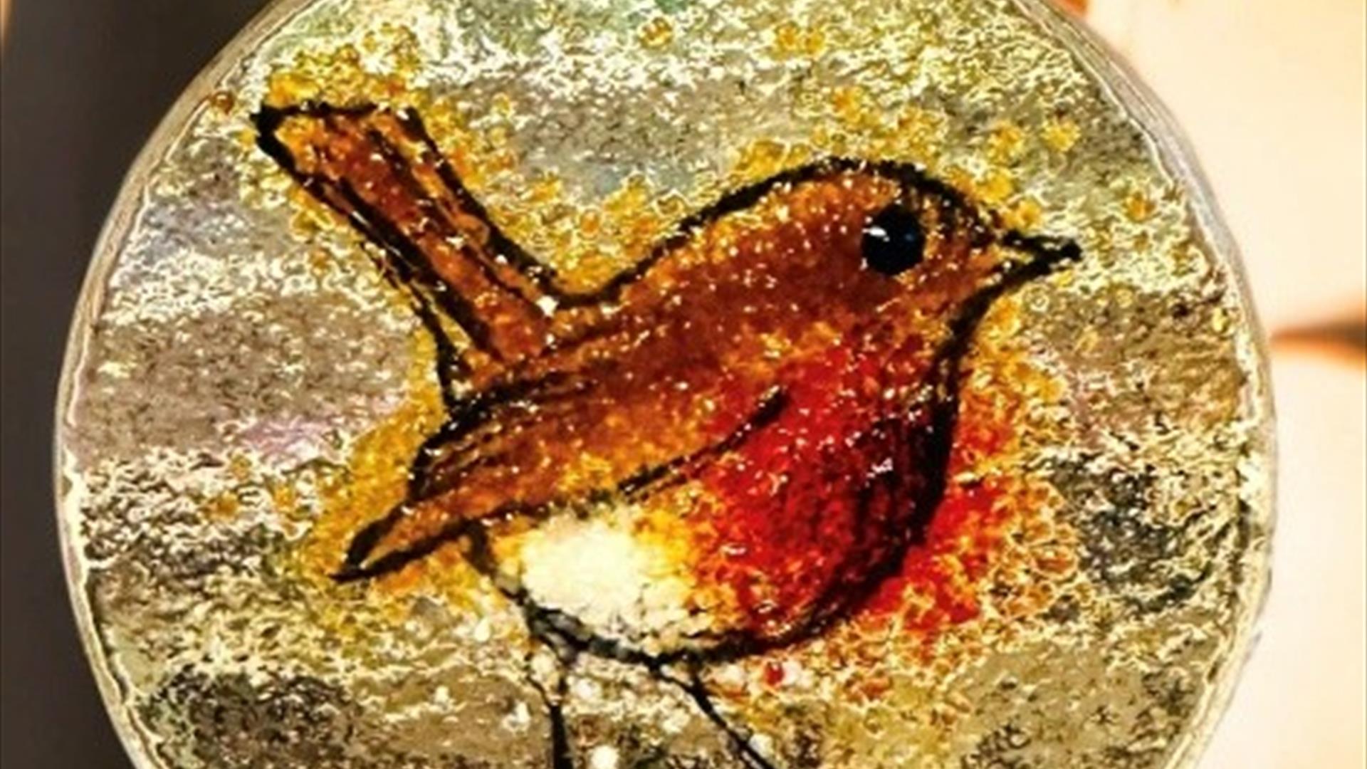 a glass decoration with a picture of a robin in the middle. a glass decoration with a picture of a robin in the middle.
