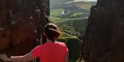 a person looks at the view of the River Roe from a mountain crevice