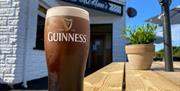 A pint of Guinness sitting on on outdoor table