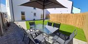 garden area with dining table, 6 chairs and parasol