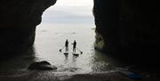 Paddleboarders on the water in a cave