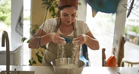 Image of one of the local producers Bronagh Duffin from Bakehouse NI sieving flour into a bowl