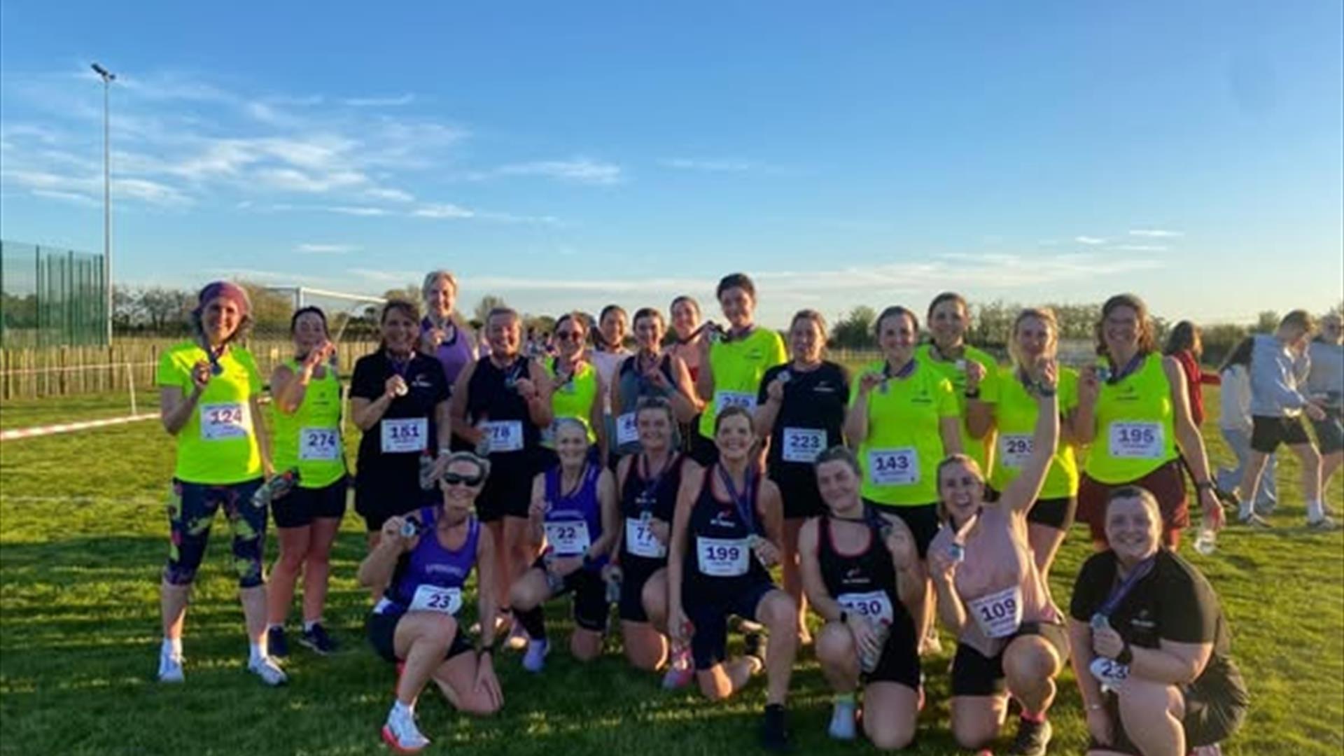the roe runners all gathered in a field in their running gear the roe runners all gathered in a field in their running gear