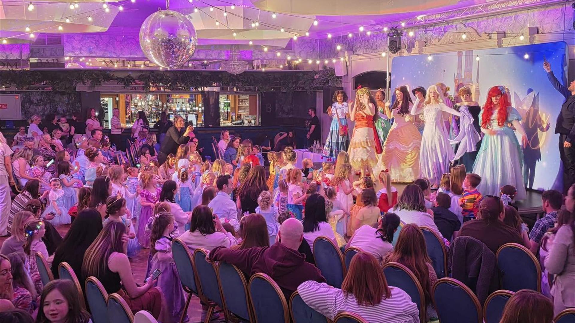 disney princesses on stage in front of a crowd disney princesses on stage in front of a crowd