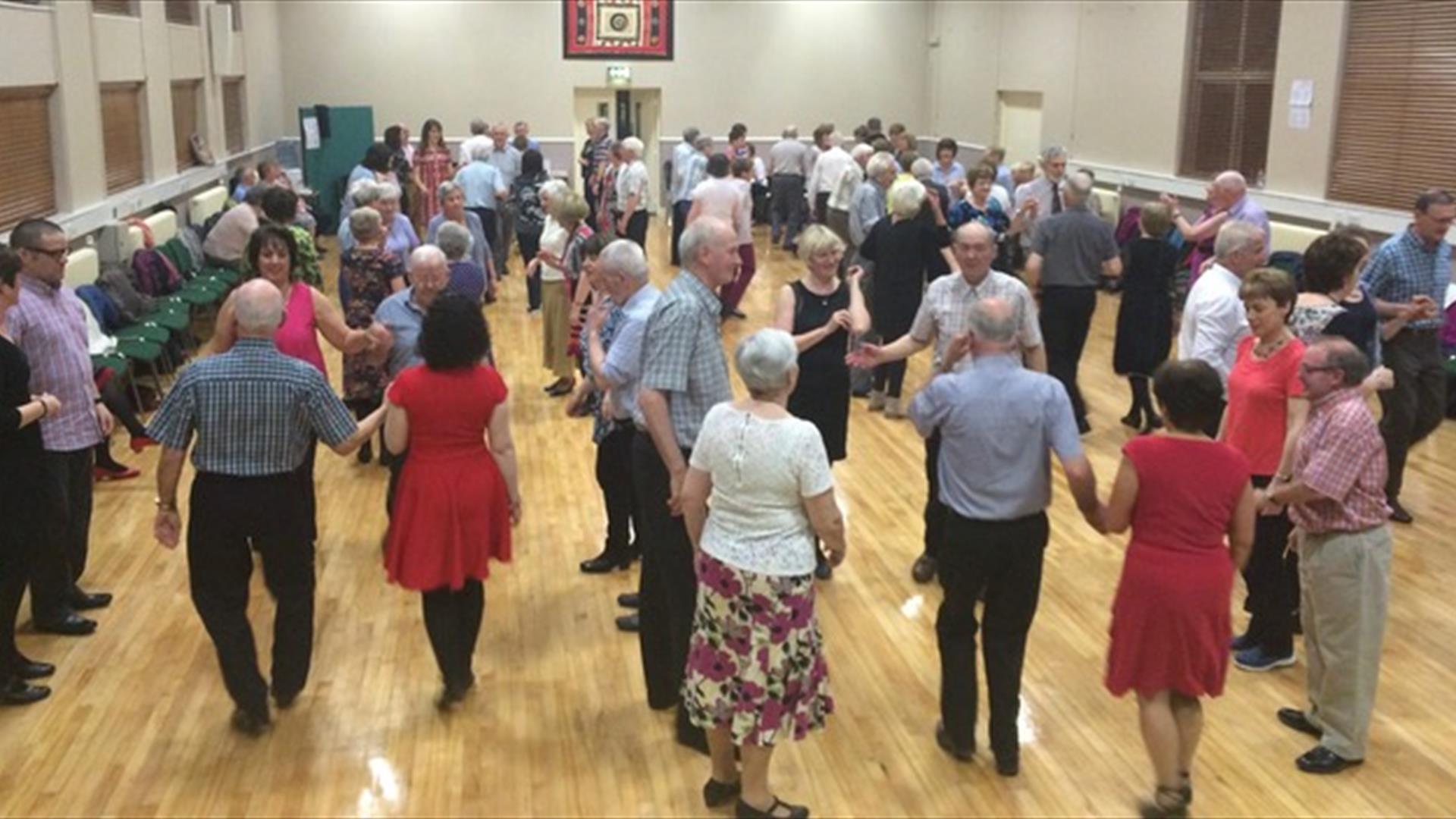 a number of people dancing in pairs and groups in a large hall a number of people dancing in pairs and groups in a large hall