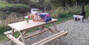 A large pine picnic table and bench set sits outside the cabin overlooking the bend in the river. It's perfect for watching out for our wildlife too,