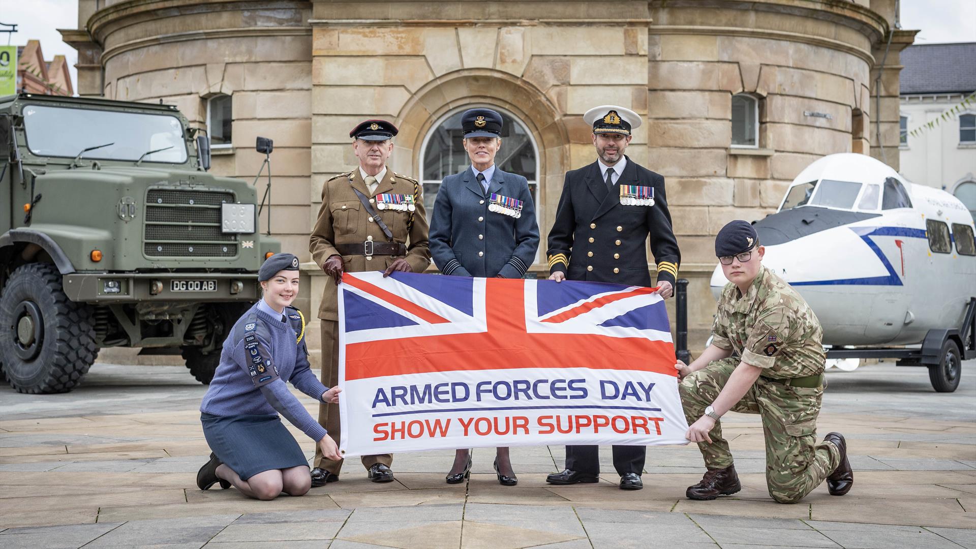 Military service men and women hold an Armed Forces Flag Military service men and women hold an Armed Forces Flag